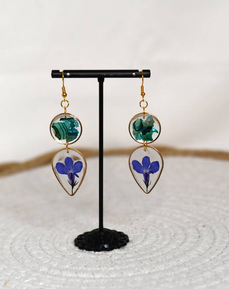 Leona oorbellen – Lobelia bloemen & abalone schelp in UV resin met gouden accenten (L 7 × B 2,5 cm)